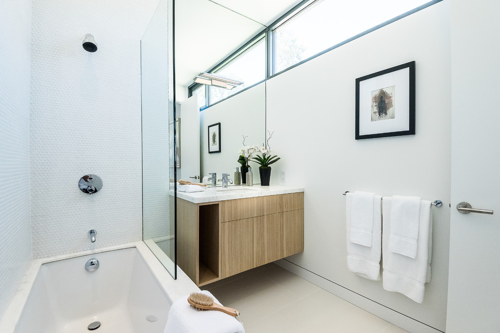 Exemple d'une salle de bain moderne en bois brun de taille moyenne pour enfant avec un placard à porte plane, une baignoire encastrée, une douche ouverte, WC à poser, un carrelage gris, des carreaux de céramique, un mur blanc, un sol en carrelage de céramique, un lavabo encastré et un plan de toilette en marbre.