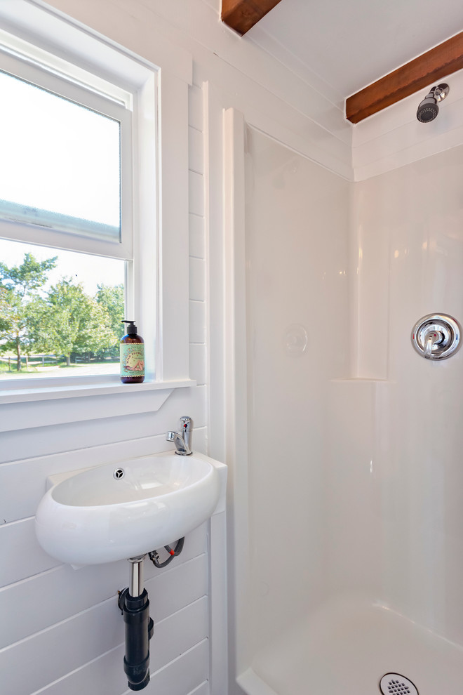 Imagen de cuarto de baño marinero pequeño con ducha empotrada, sanitario de una pieza, paredes blancas y lavabo suspendido
