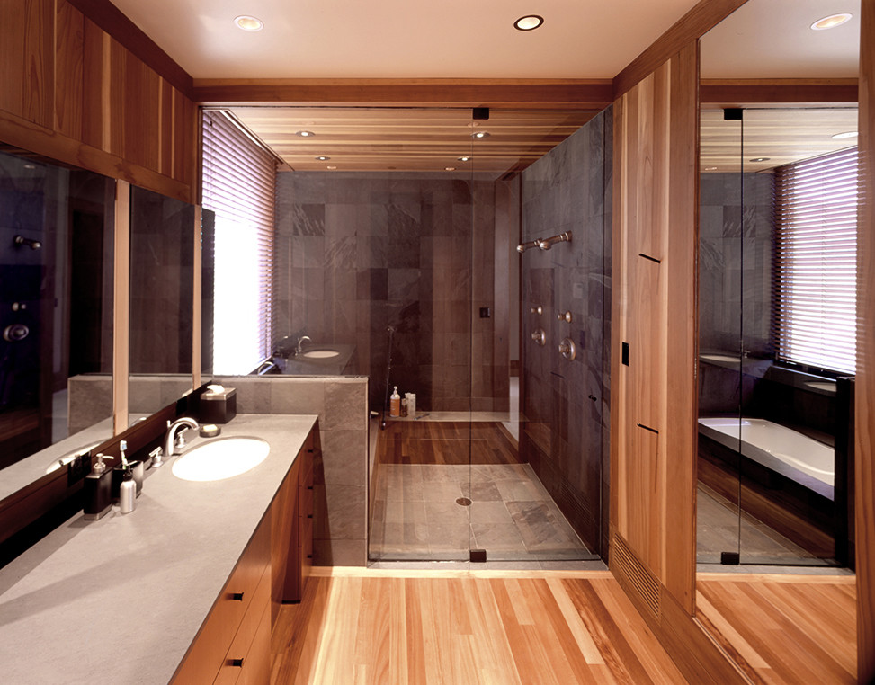 Ispirazione per una stanza da bagno padronale minimalista con ante lisce, ante in legno scuro, doccia alcova, piastrelle grigie, pavimento in legno massello medio e lavabo sottopiano