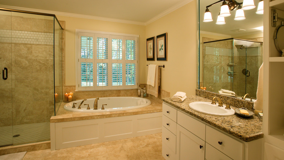 Diseño de cuarto de baño principal clásico con lavabo encastrado, armarios estilo shaker, puertas de armario blancas, encimera de granito, bañera encastrada, ducha empotrada, baldosas y/o azulejos beige, losas de piedra, paredes beige y suelo de mármol