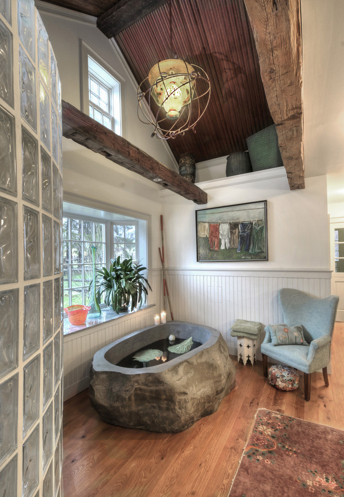 Foto på ett stort lantligt en-suite badrum, med ett konsol handfat, ett fristående badkar, en öppen dusch, vita väggar, mellanmörkt trägolv, marmorbänkskiva och med dusch som är öppen