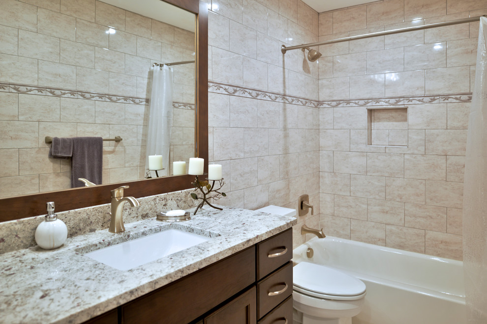 Idée de décoration pour une très grande salle de bain principale minimaliste en bois foncé avec un plan de toilette gris, un bain bouillonnant, un combiné douche/baignoire, WC à poser, un carrelage beige, un mur beige, un lavabo encastré, une cabine de douche avec un rideau et un sol beige.