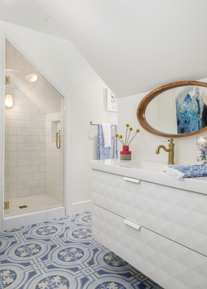 Photo of a beach style bathroom in Atlanta with flat-panel cabinets, white cabinets, an alcove shower, white tiles, white walls, cement flooring, an integrated sink, blue floors, a hinged door and white worktops.