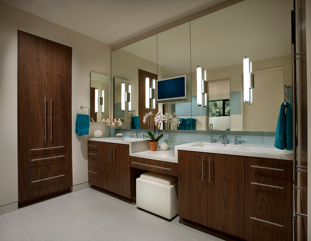 Foto de cuarto de baño contemporáneo con lavabo bajoencimera, armarios con paneles lisos, puertas de armario de madera en tonos medios y baldosas y/o azulejos azules