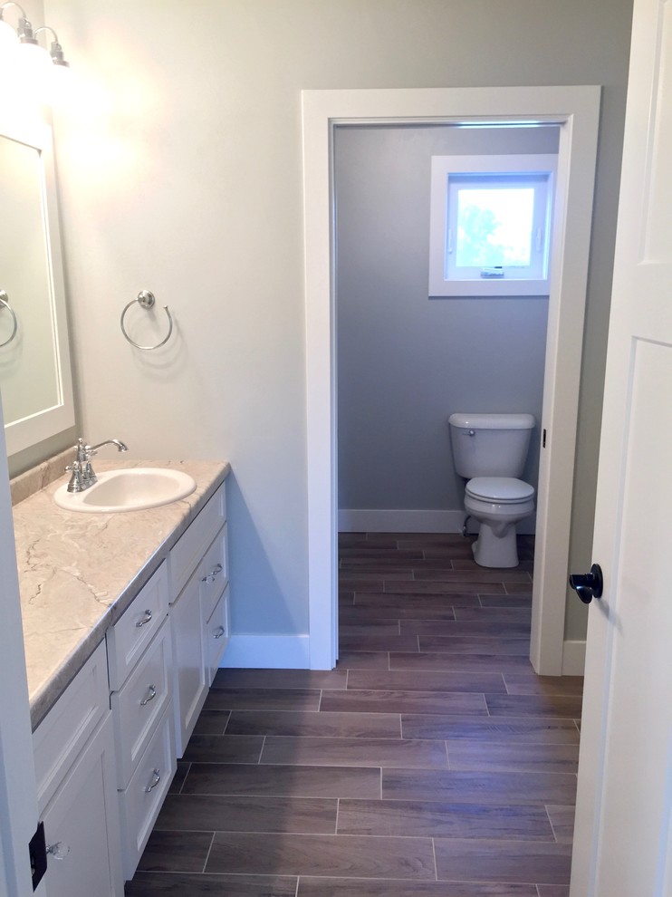 Foto di una stanza da bagno per bambini american style di medie dimensioni con lavabo da incasso, ante in stile shaker, ante bianche, top in laminato, pareti grigie e pavimento in vinile