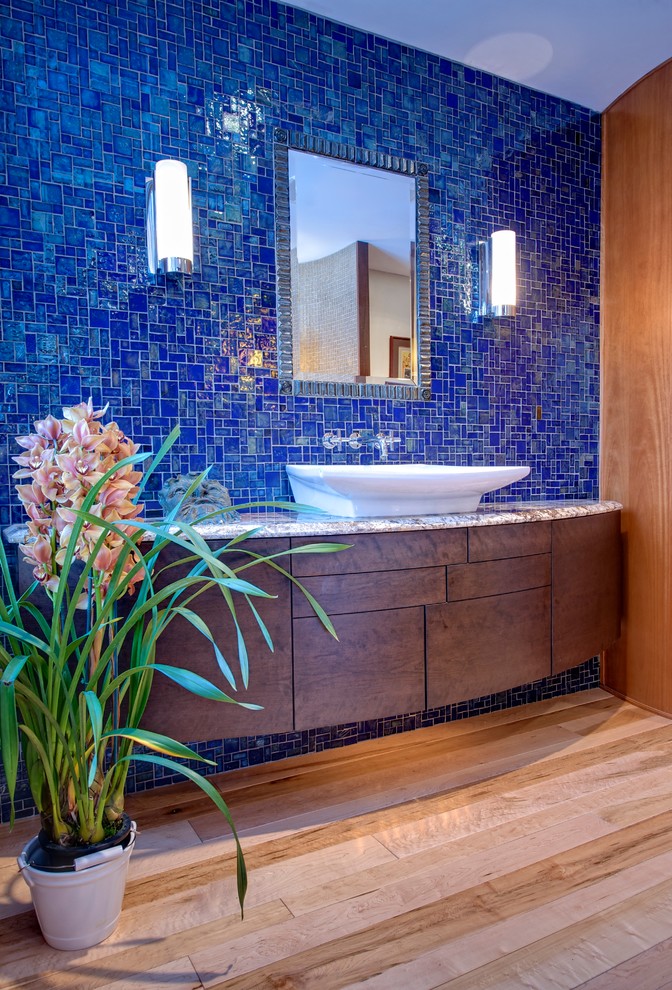Inspiration for a large modern master blue tile and mosaic tile light wood floor bathroom remodel in Philadelphia with flat-panel cabinets, dark wood cabinets, a vessel sink, granite countertops and a hinged shower door