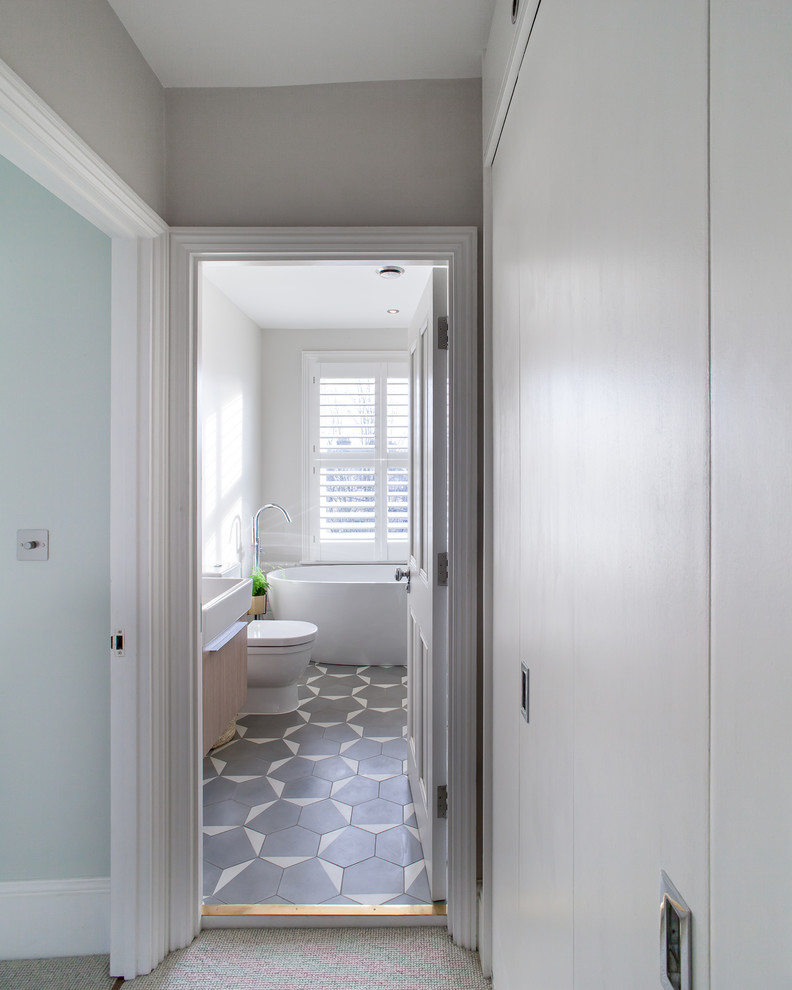 Foto de cuarto de baño contemporáneo de tamaño medio con bañera exenta, ducha abierta, baldosas y/o azulejos grises, paredes blancas, suelo de baldosas de cerámica y lavabo tipo consola