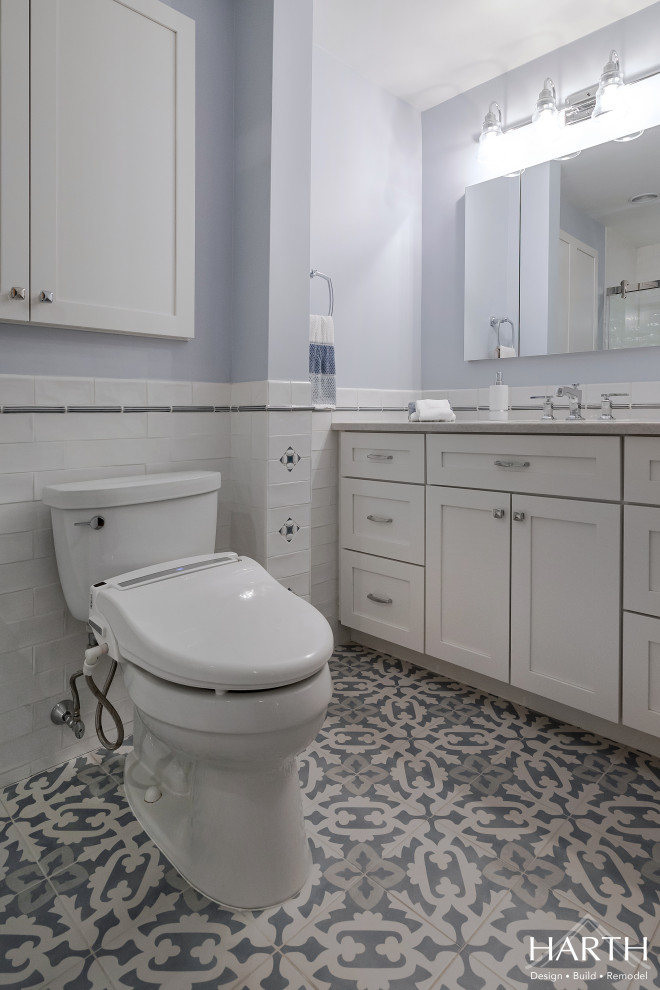 Idées déco pour une salle de bain classique de taille moyenne pour enfant avec un placard à porte shaker, des portes de placard blanches, une baignoire en alcôve, un combiné douche/baignoire, WC séparés, un carrelage blanc, un carrelage métro, un mur bleu, carreaux de ciment au sol, un lavabo encastré, un plan de toilette en quartz modifié, un sol gris, une cabine de douche à porte coulissante, un plan de toilette gris, une niche, meuble simple vasque, meuble-lavabo encastré et boiseries.