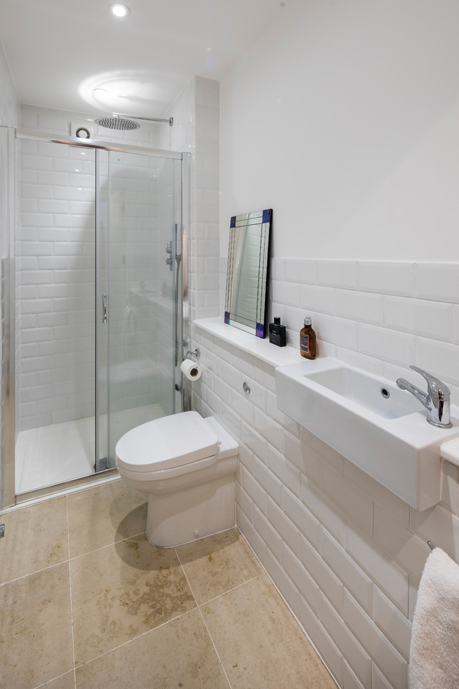 Ejemplo de cuarto de baño actual con sanitario de una pieza, baldosas y/o azulejos blancos, paredes blancas, lavabo suspendido, suelo beige y ducha con puerta corredera