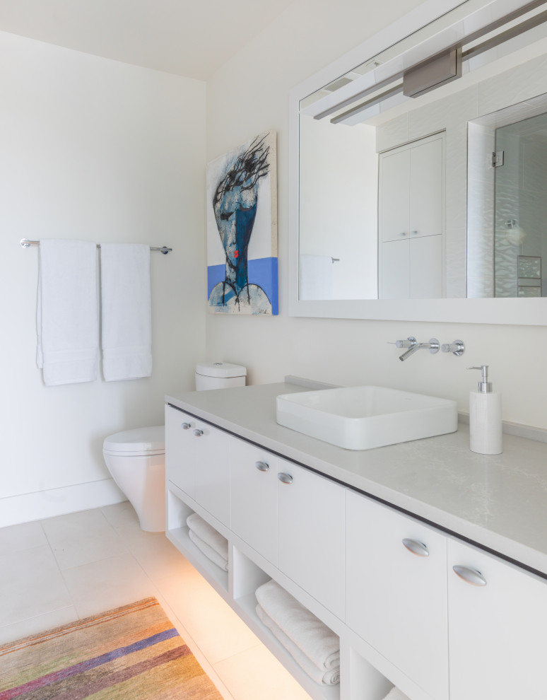 Modelo de cuarto de baño único y flotante marinero con armarios con paneles lisos, puertas de armario blancas, paredes blancas, lavabo sobreencimera, suelo gris y encimeras grises