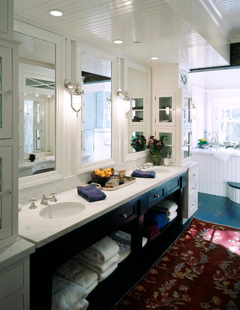 На фото: главная ванная комната среднего размера в стиле неоклассика (современная классика) с фасадами островного типа, черными фасадами, накладной ванной, раздельным унитазом, белыми стенами, деревянным полом, врезной раковиной, мраморной столешницей, синим полом и белой столешницей