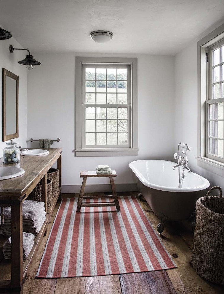 Inspiration för lantliga brunt badrum, med öppna hyllor, bruna skåp, ett badkar med tassar, vita väggar, mellanmörkt trägolv, ett nedsänkt handfat, träbänkskiva och brunt golv