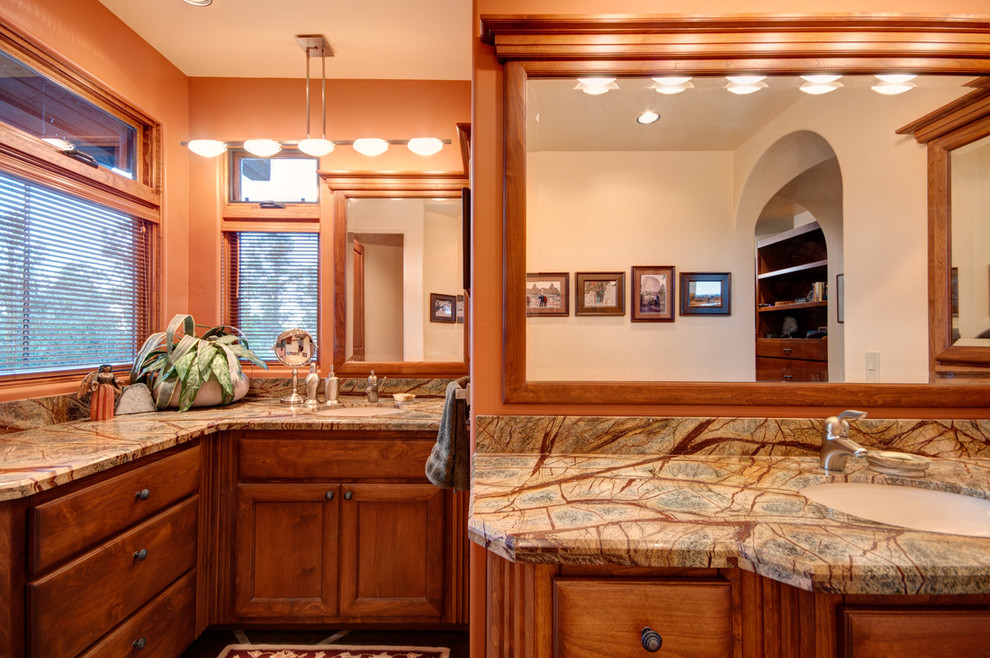 Foto di un'ampia stanza da bagno padronale tradizionale con ante in legno scuro, pareti arancioni, pavimento in cemento, lavabo sottopiano, top in marmo e ante in stile shaker