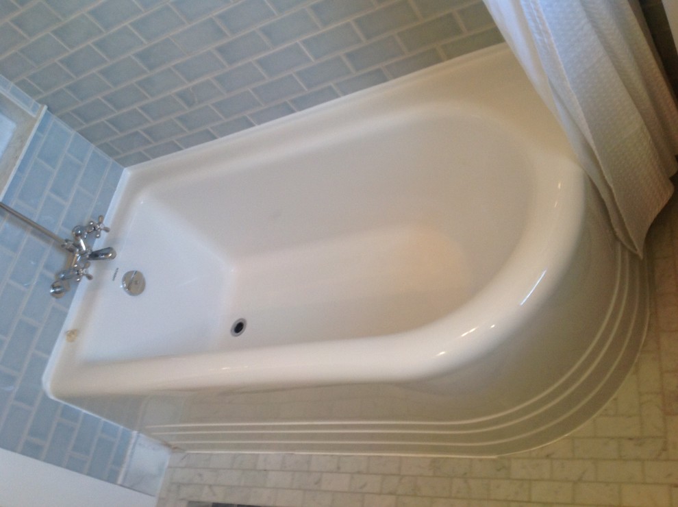 Foto di una piccola stanza da bagno tradizionale con lavabo a consolle, ante lisce, ante grigie, vasca ad angolo, vasca/doccia, piastrelle blu, pareti blu e pavimento in marmo