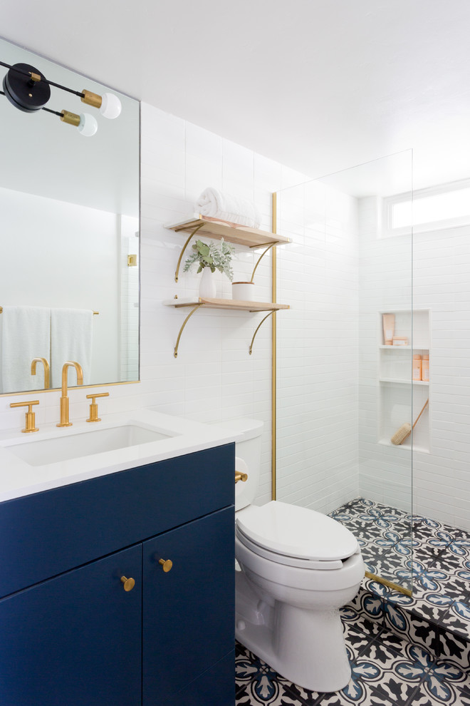 Ejemplo de cuarto de baño clásico renovado con puertas de armario azules, baldosas y/o azulejos blancos, armarios con paneles lisos, sanitario de dos piezas, paredes blancas, aseo y ducha, lavabo bajoencimera, suelo multicolor y espejo con luz