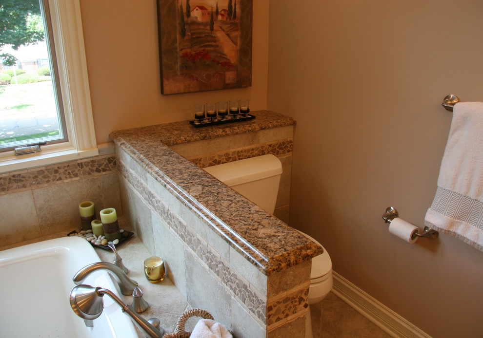 Idée de décoration pour une grande salle de bain principale tradition en bois brun avec un lavabo encastré, un placard avec porte à panneau surélevé, un plan de toilette en granite, une baignoire posée, une douche d'angle, WC séparés, un carrelage beige, des carreaux de porcelaine, un mur beige et un sol en carrelage de porcelaine.