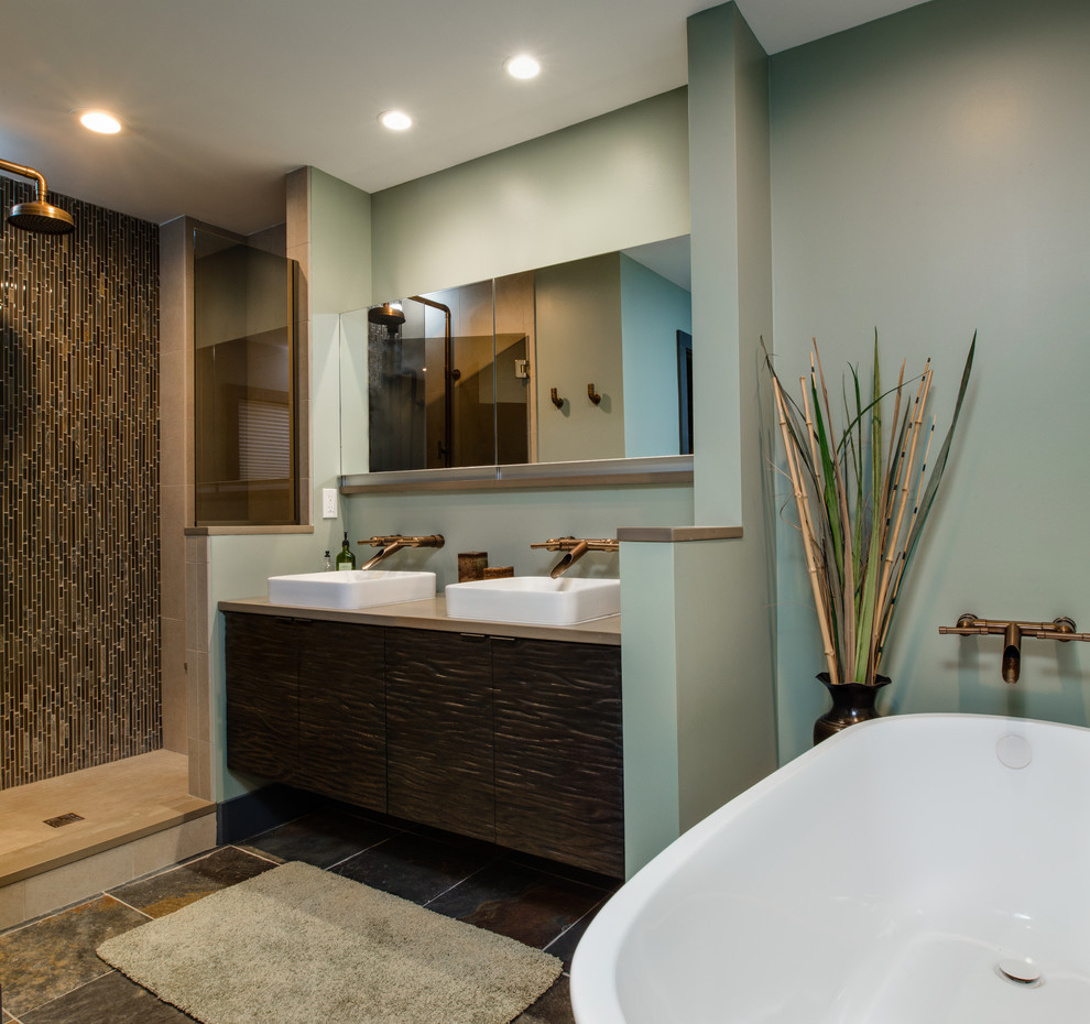 Photo of a large bohemian ensuite bathroom in Other with a vessel sink, flat-panel cabinets, brown cabinets, engineered stone worktops, a freestanding bath, a walk-in shower, a one-piece toilet, multi-coloured tiles, glass tiles, beige walls and terracotta flooring.