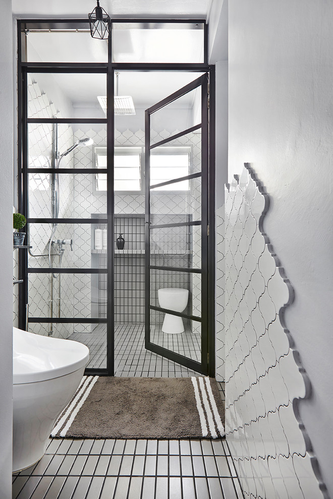 Modern inredning av ett badrum med dusch, med våtrum, vit kakel, vita väggar, grått golv och dusch med gångjärnsdörr