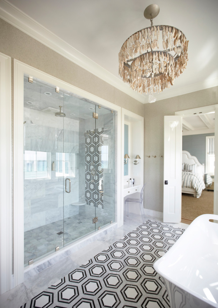 На фото: ванная комната в морском стиле с отдельно стоящей ванной, душем в нише, белой плиткой и бежевыми стенами с