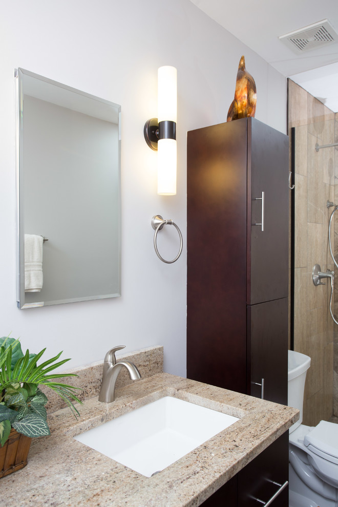This is an example of a medium sized classic ensuite bathroom in Chicago with a submerged sink, flat-panel cabinets, dark wood cabinets, granite worktops, an alcove shower, a two-piece toilet, multi-coloured tiles, stone tiles, grey walls and porcelain flooring.