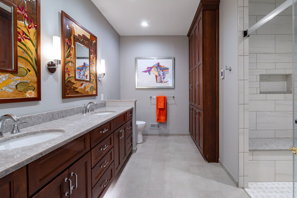 Exempel på ett mellanstort klassiskt grå grått en-suite badrum, med skåp i shakerstil, skåp i mellenmörkt trä, en dusch i en alkov, en toalettstol med separat cisternkåpa, vit kakel, porslinskakel, grå väggar, klinkergolv i porslin, ett undermonterad handfat, bänkskiva i kvarts, grått golv och dusch med skjutdörr