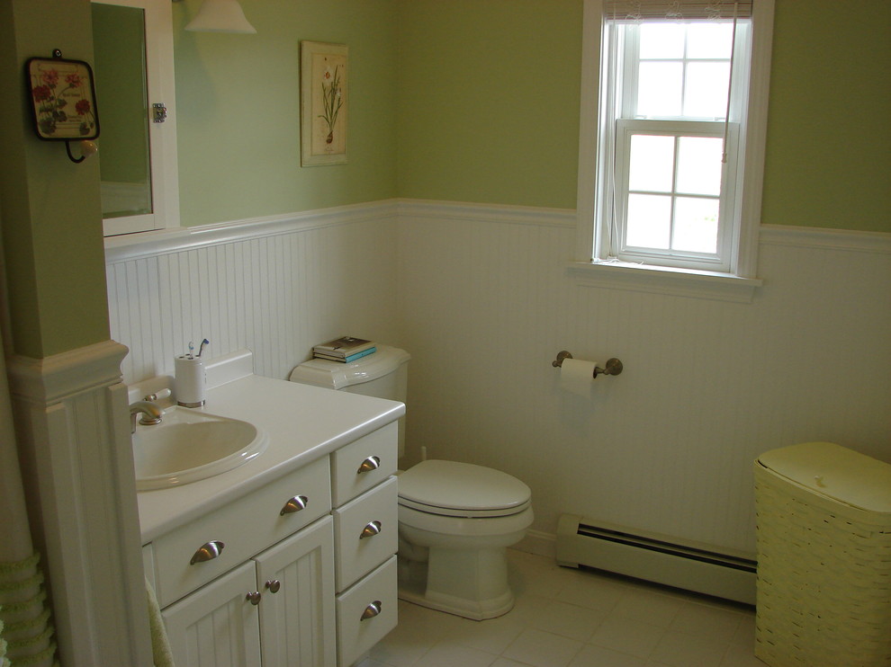 Стильный дизайн: ванная комната среднего размера в классическом стиле с белыми фасадами, раздельным унитазом, белой плиткой, керамической плиткой, зелеными стенами, полом из керамической плитки, накладной раковиной и столешницей из ламината - последний тренд