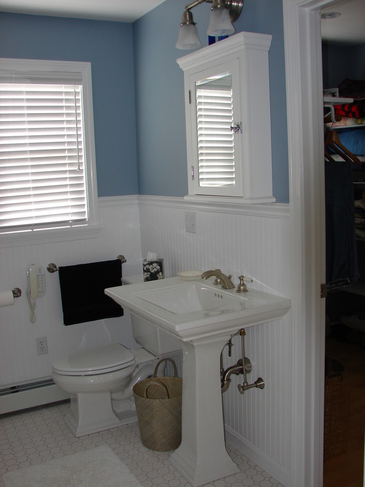 Foto de cuarto de baño clásico de tamaño medio con sanitario de dos piezas, baldosas y/o azulejos blancos, baldosas y/o azulejos de porcelana, paredes azules, suelo de baldosas de porcelana, lavabo con pedestal, bañera encastrada y ducha esquinera