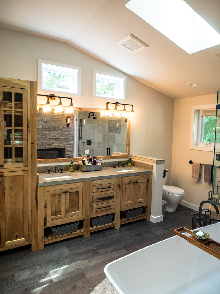 Mid-sized mountain style master gray tile and ceramic tile ceramic tile and gray floor bathroom photo in Detroit with recessed-panel cabinets, medium tone wood cabinets, a two-piece toilet, beige walls, an undermount sink, concrete countertops and a hinged shower door