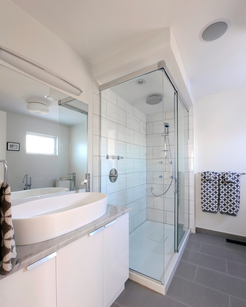 Inspiration för mellanstora minimalistiska en-suite badrum, med ett fristående handfat, släta luckor, vita skåp, marmorbänkskiva, en hörndusch, vit kakel, porslinskakel, vita väggar och klinkergolv i porslin