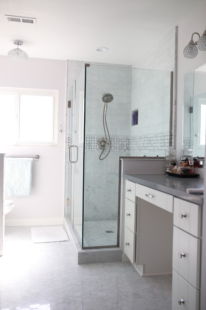 Photo of a medium sized modern ensuite bathroom in Orange County with flat-panel cabinets, white cabinets, a corner shower, white tiles, marble tiles, quartz worktops, a hinged door, grey walls, marble flooring, white floors, a one-piece toilet and a submerged sink.
