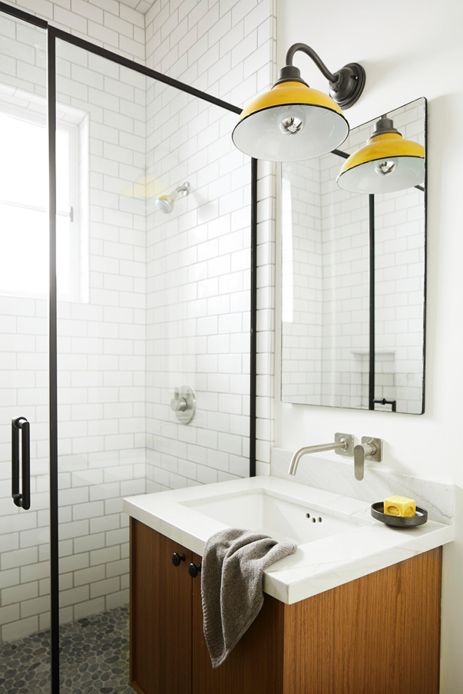 Lantlig inredning av ett litet vit vitt badrum med dusch, med släta luckor, skåp i mellenmörkt trä, en dusch i en alkov, vit kakel, keramikplattor, vita väggar, klinkergolv i småsten, ett undermonterad handfat, bänkskiva i kvartsit, grått golv och dusch med gångjärnsdörr