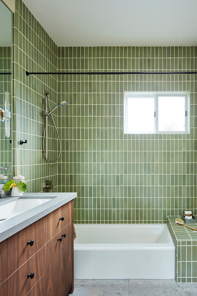 Modern inredning av ett mellanstort grå grått badrum med dusch, med släta luckor, skåp i mellenmörkt trä, ett badkar i en alkov, en dusch/badkar-kombination, grön kakel, keramikplattor, vita väggar, klinkergolv i porslin, ett avlångt handfat, bänkskiva i kvarts, grått golv och dusch med duschdraperi