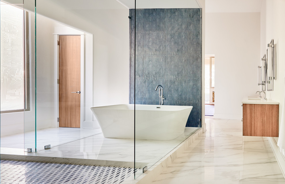 Exemple d'une très grande salle de bain principale tendance en bois brun avec un placard à porte plane, un plan de toilette en quartz modifié, un plan de toilette blanc, une baignoire indépendante, un carrelage gris, un mur blanc, un sol en marbre, un lavabo encastré et un sol gris.