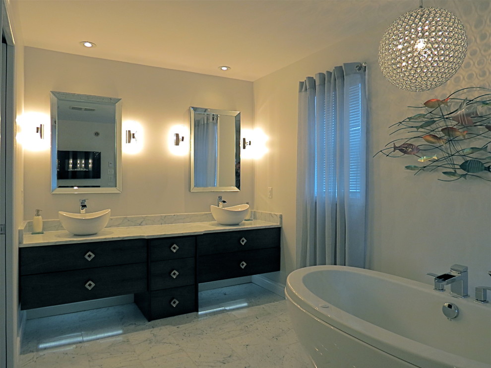 Modern inredning av ett mellanstort en-suite badrum, med ett fristående handfat, släta luckor, skåp i mörkt trä, marmorbänkskiva, ett fristående badkar, vita väggar och marmorgolv