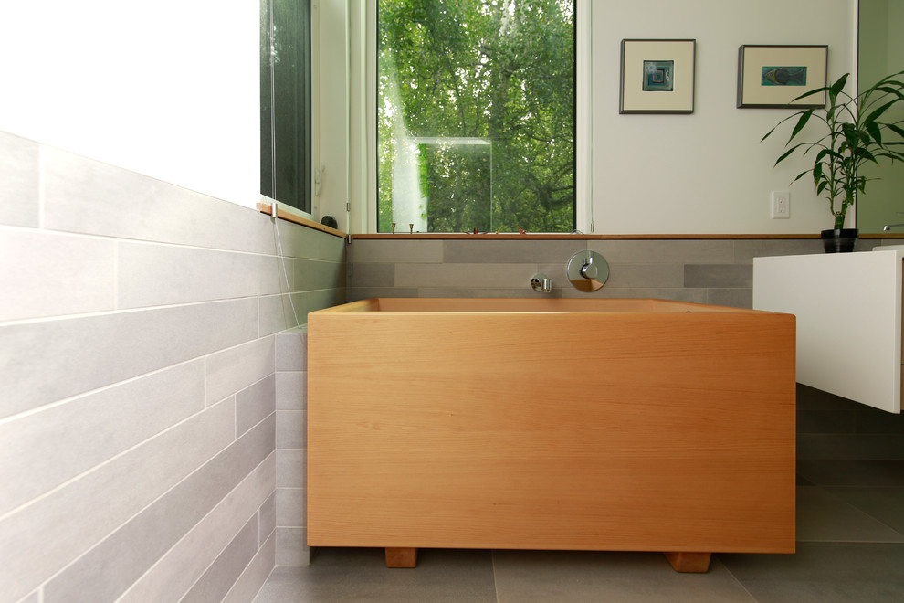 This is an example of a large contemporary ensuite bathroom in Other with flat-panel cabinets, white cabinets, a freestanding bath, grey tiles, porcelain tiles, white walls and porcelain flooring.