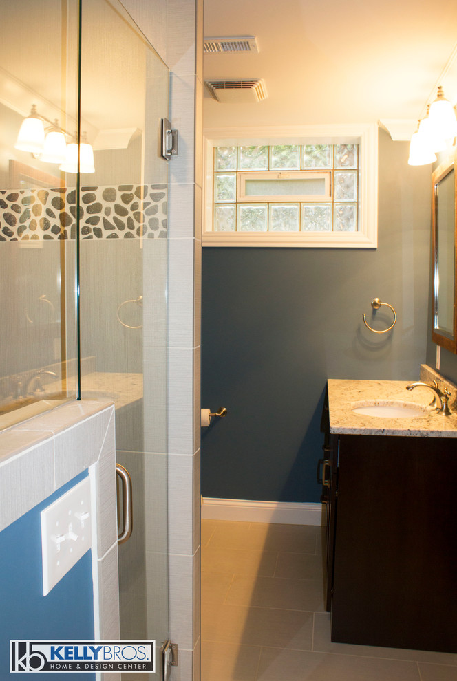 Transitional gray tile and stone tile doorless shower photo in Cincinnati with an undermount sink, shaker cabinets, dark wood cabinets, granite countertops and blue walls