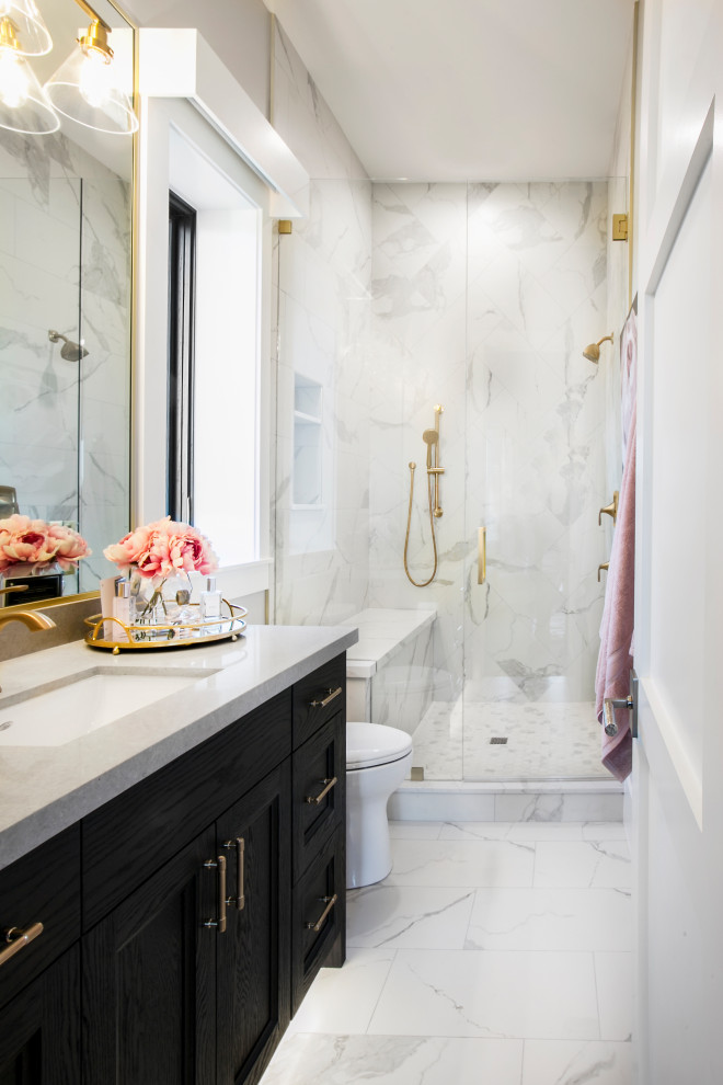 На фото: большая главная ванная комната в стиле неоклассика (современная классика) с серыми фасадами, отдельно стоящей ванной, душем в нише, раздельным унитазом, белой плиткой, керамической плиткой, серыми стенами, мраморным полом, врезной раковиной, столешницей из искусственного кварца, белым полом, душем с распашными дверями, белой столешницей, тумбой под две раковины, встроенной тумбой и фасадами в стиле шейкер