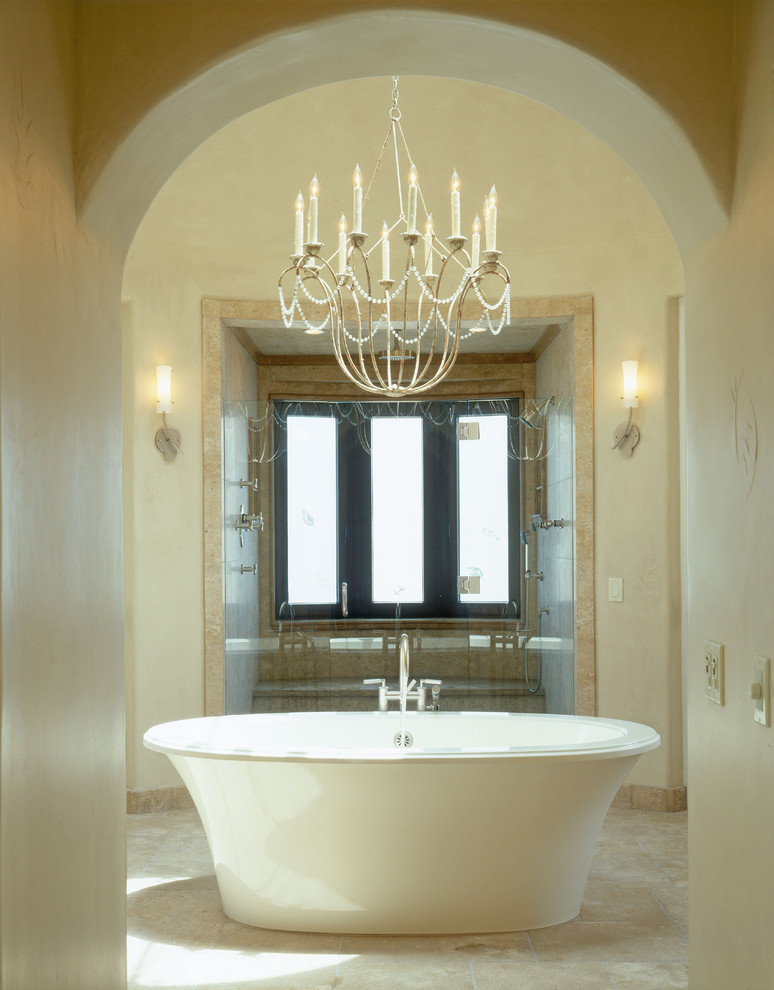 Idéer för ett mycket stort medelhavsstil en-suite badrum, med beige kakel, stenhäll, beige väggar, kalkstensgolv, ett fristående badkar, en dusch i en alkov, beiget golv och dusch med gångjärnsdörr