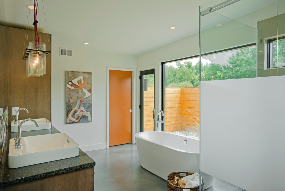 This is an example of a large contemporary ensuite bathroom in Baltimore with a vessel sink, flat-panel cabinets, medium wood cabinets, engineered stone worktops, a freestanding bath, a corner shower, multi-coloured tiles, ceramic tiles, concrete flooring, a two-piece toilet, beige walls, grey floors and a hinged door.