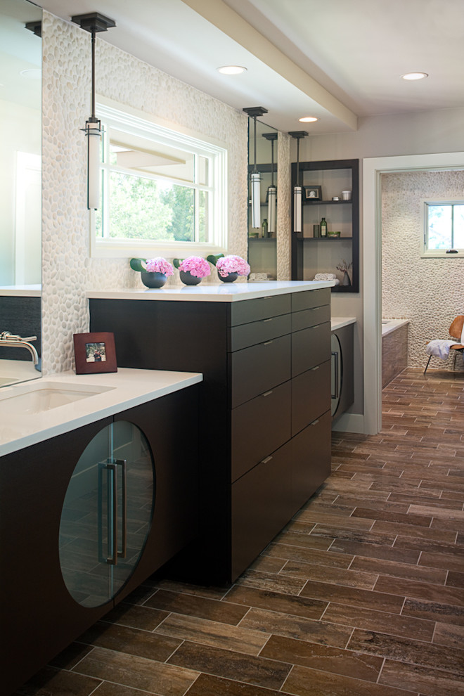 Пример оригинального дизайна: ванная комната в современном стиле с врезной раковиной, галечной плиткой и черными фасадами
