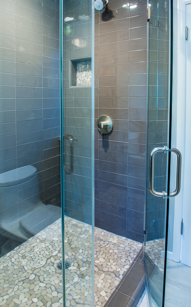Esempio di una piccola stanza da bagno con doccia minimal con doccia alcova, piastrelle grigie, piastrelle di vetro, pareti grigie, pavimento con piastrelle di ciottoli, pavimento beige e porta doccia a battente