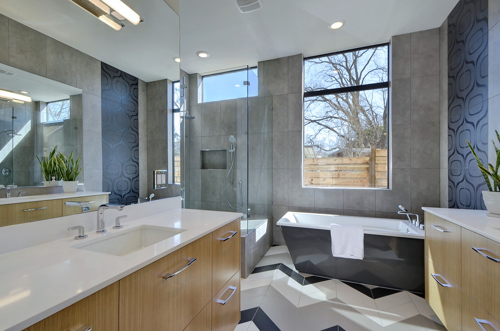 Inspiration för moderna en-suite badrum, med släta luckor, skåp i mellenmörkt trä, ett fristående badkar, en hörndusch, grå kakel, grå väggar, ett undermonterad handfat och dusch med gångjärnsdörr