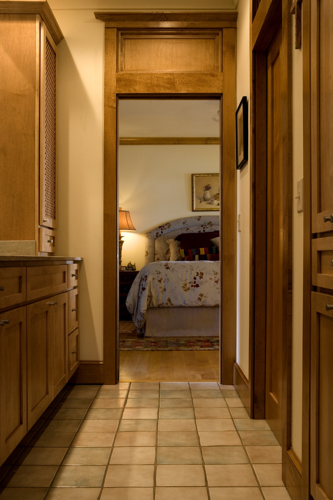 Exemple d'une salle de bain principale tendance en bois brun de taille moyenne avec un placard à porte shaker, un plan de toilette en calcaire, un carrelage vert, des carreaux de céramique, un mur beige et un sol en carrelage de céramique.