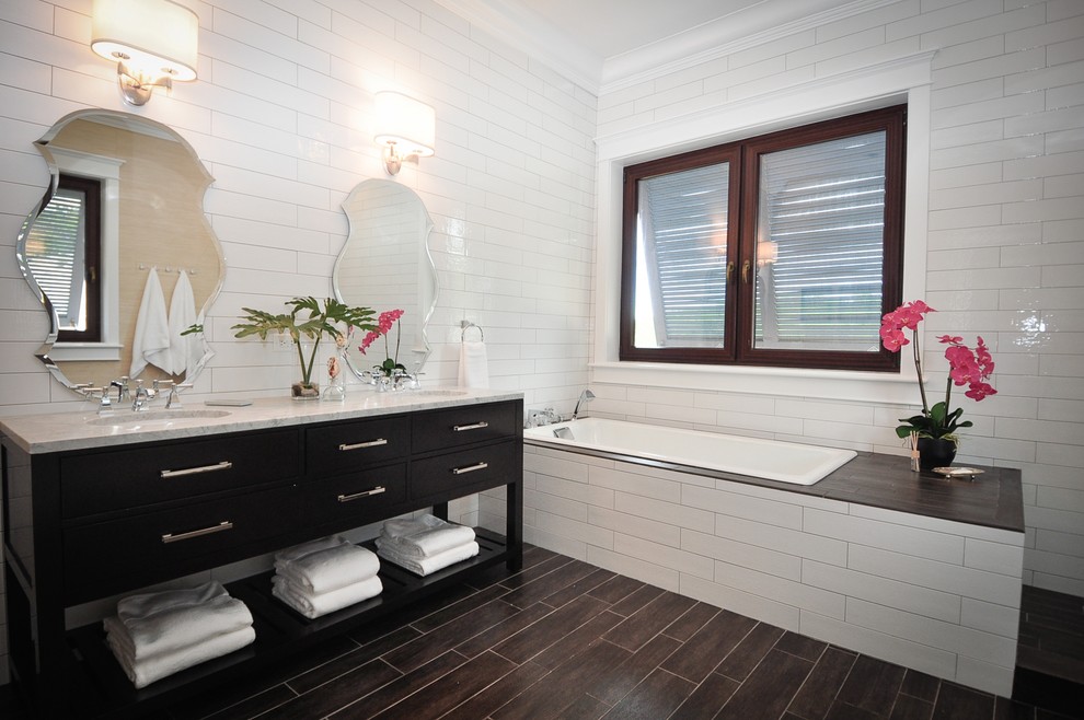 На фото: главная ванная комната среднего размера в морском стиле с плоскими фасадами, черными фасадами, угловой ванной, белой плиткой, плиткой кабанчик, белыми стенами, полом из керамогранита, врезной раковиной, мраморной столешницей и коричневым полом