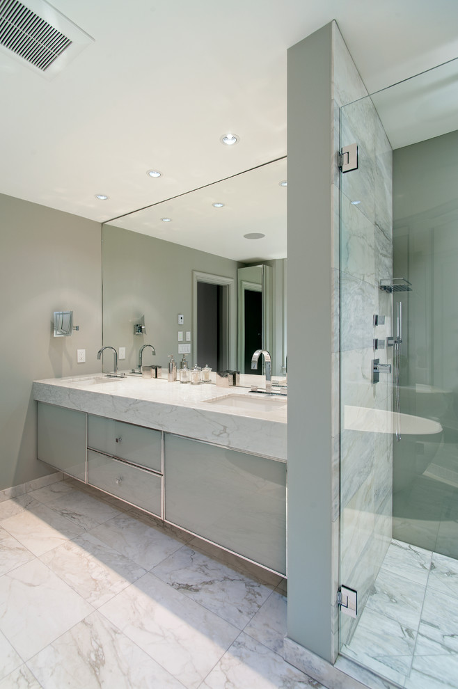 На фото: ванная комната в современном стиле с врезной раковиной, стеклянными фасадами, серыми стенами и мраморным полом с
