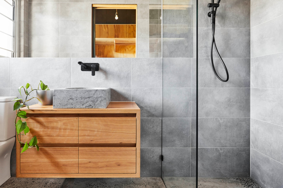 Immagine di una stanza da bagno padronale design con ante in legno scuro, top in legno, ante lisce, doccia alcova, piastrelle grigie, lavabo a bacinella, pavimento grigio e mobile bagno sospeso