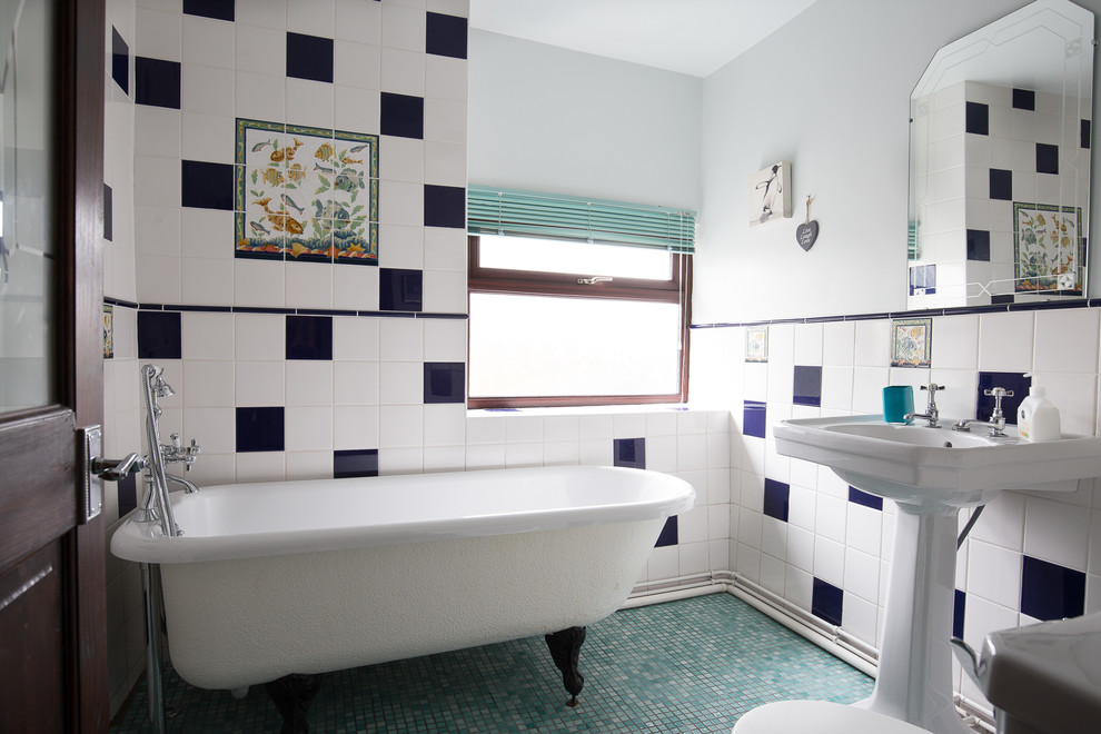 Réalisation d'une petite salle d'eau tradition avec une baignoire sur pieds, un carrelage bleu, un carrelage blanc, des carreaux de céramique, un mur blanc, un sol en carrelage de terre cuite, un lavabo de ferme et une fenêtre.