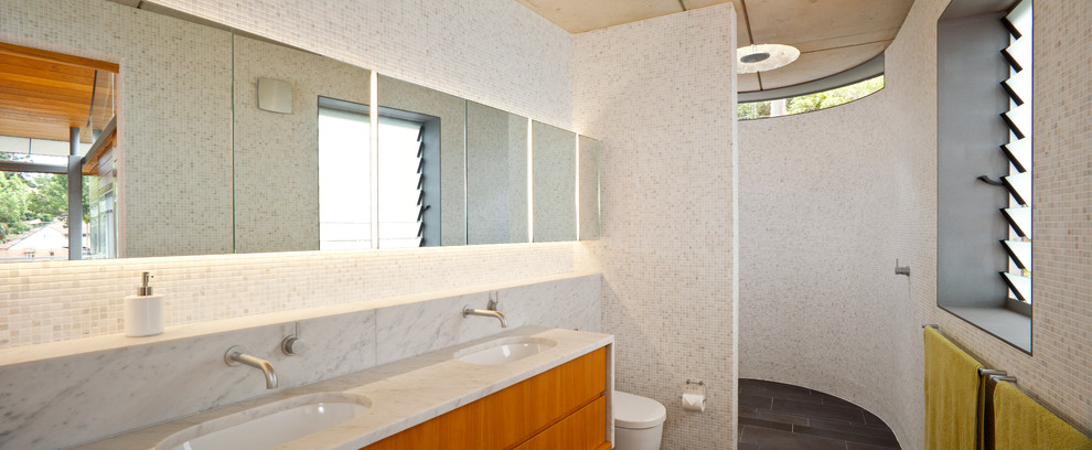 Immagine di una stanza da bagno padronale di medie dimensioni con lavabo sottopiano, ante lisce, ante in legno scuro, top in marmo, doccia alcova, WC sospeso, piastrelle grigie, pareti bianche e pavimento in ardesia