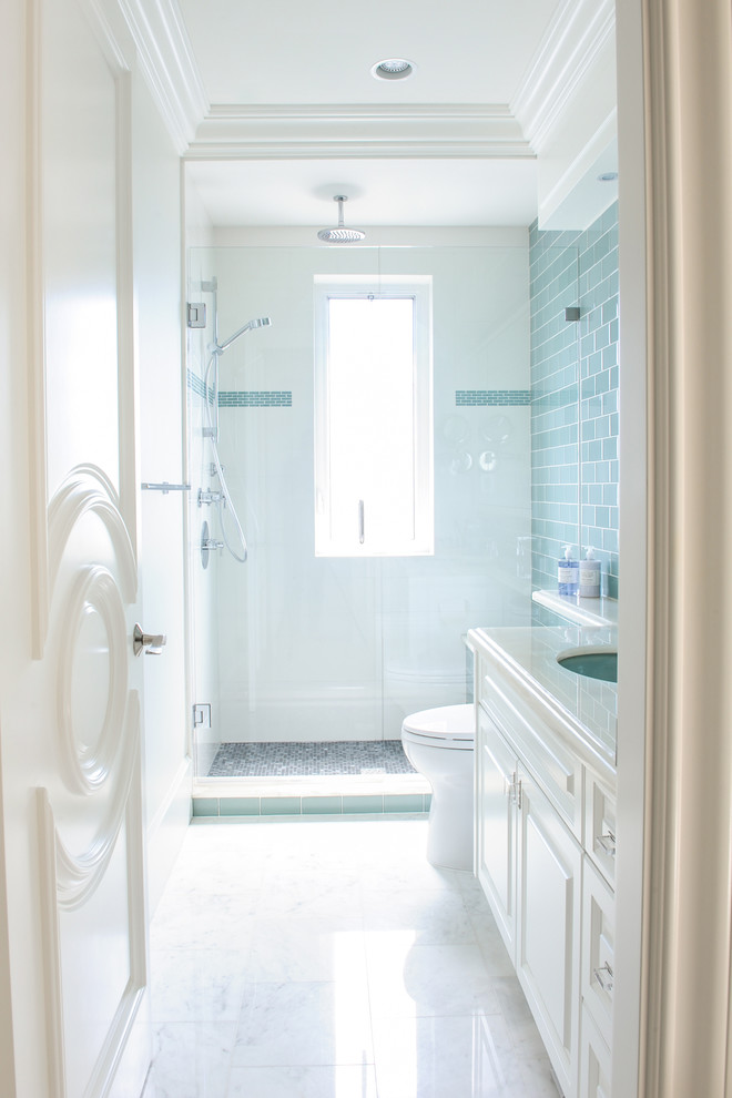 Foto di una stanza da bagno con doccia classica di medie dimensioni con ante con bugna sagomata, ante bianche, doccia alcova, piastrelle blu, pareti bianche, pavimento in marmo, lavabo sottopiano, WC monopezzo e piastrelle di vetro
