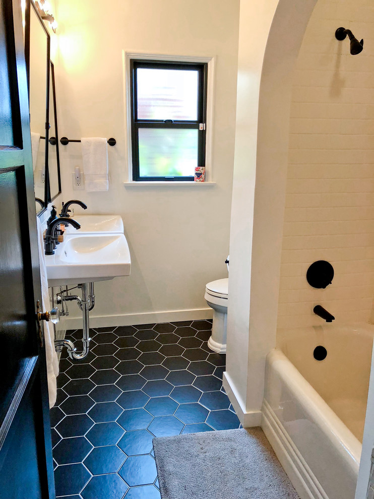 Bathroom - small modern white tile and subway tile ceramic tile and black floor bathroom idea in Los Angeles with a two-piece toilet, white walls and a wall-mount sink